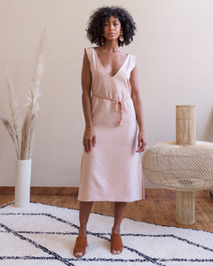 Model, Natalia, wearing Soluna Collective's romp around reversible dress. The fabric is a lightweight Tencel and is a light peach color. Size M shown. 