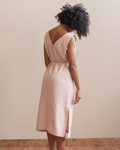 Model, Natalia, wearing Soluna Collective's romp around reversible dress. The fabric is a lightweight Tencel and is a light peach color. Size M shown. 